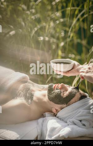Estetista applicare la maschera sul viso della donna Foto Stock