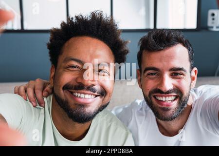 Amici multirazziali felici che prendono selfie a casa Foto Stock
