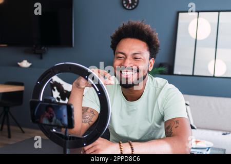 Felice influencer fare vlog attraverso smartphone a casa Foto Stock