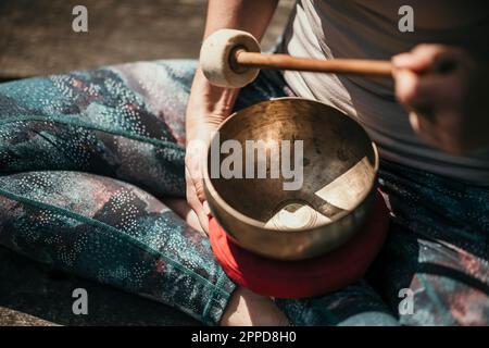 Donna che medita con la coppa di canto tibetana Foto Stock