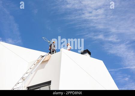 Tecnico in piedi sul tetto sotto il cielo Foto Stock