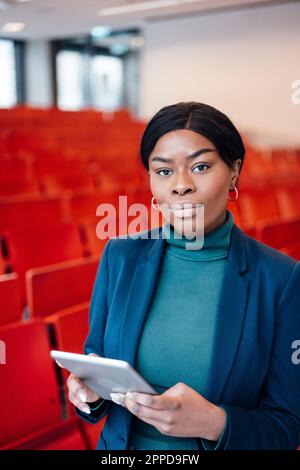 Giovane donna sicura con un tablet PC in auditorium Foto Stock