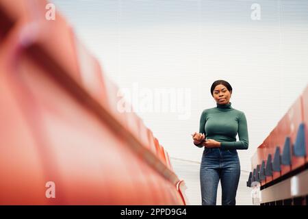 Giovane donna sicura con un tablet PC in piedi in auditorium Foto Stock