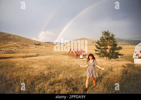 Felice giovane donna che cammina nel prato Foto Stock