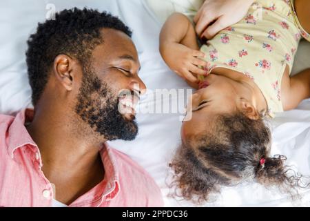 Felice uomo sdraiato con la ragazza sul letto Foto Stock