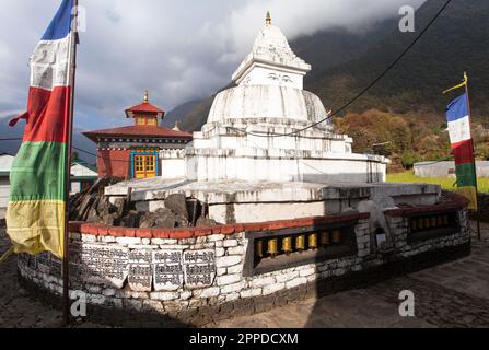 Stupa con bandiere di preghiera e ruote in viaggio da Lukla a Namche bazar nel villaggio chaurikharka vicino al villaggio cheplung - nepal Foto Stock