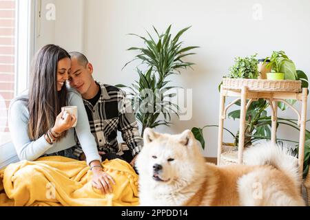 Coppia affettuosa con caffè e cane in primo piano Foto Stock