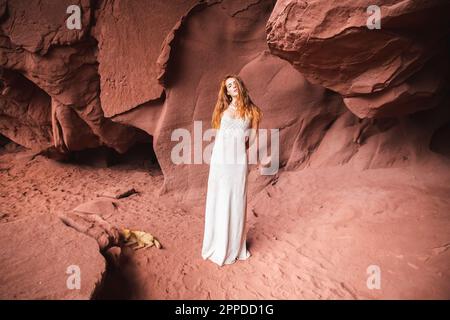 Giovane donna in piedi nella grotta rossa Foto Stock
