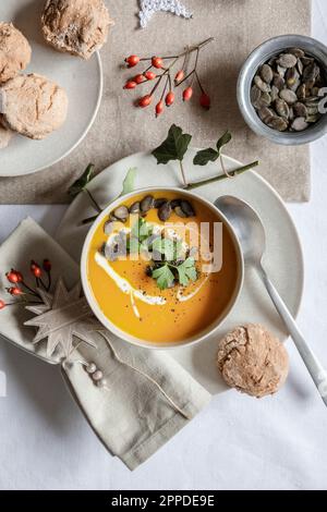 Shot studio di ciotola di zuppa di zucca con panini fatti in casa nel contesto di Natale Foto Stock