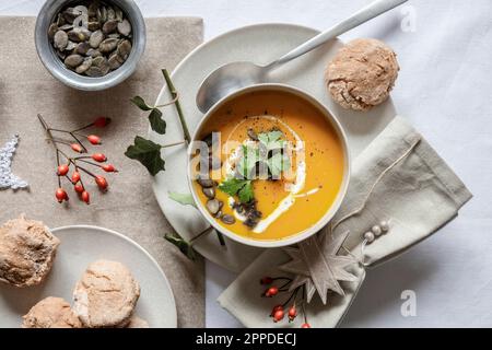 Shot studio di ciotola di zuppa di zucca con panini fatti in casa nel contesto di Natale Foto Stock