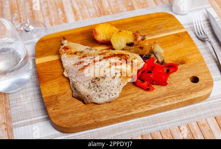 Maiale fritto con patate e pepe servito su tavola di legno Foto Stock