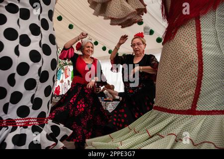 Barcellona, Spagna. 23rd Apr, 2023. Donne che indossano costumi tipici di Siviglia (abiti rotondi), ballano Sevillanas durante il 50th° anniversario della Fiera di aprile a Barcellona. Migliaia di persone hanno visitato la Feria de Abril a Barcellona domenica 23 aprile in concomitanza con l'apertura della famosa Feria de Sevilla. Donne e uomini danzavano sevillanas in costumi tradizionali. Credit: SOPA Images Limited/Alamy Live News Foto Stock