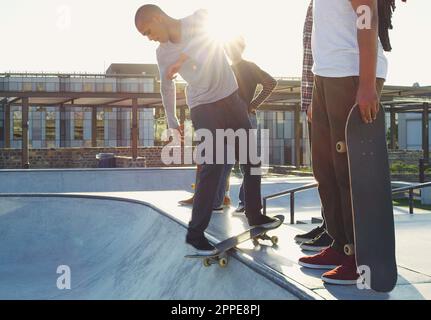 Il pattinaggio fa parte della nostra vita. un gruppo di amici che pattinano insieme sui loro skateboard in uno skatepark. Foto Stock