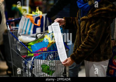 L'illustrazione mostra un cliente che controlla la ricevuta cartacea del suo cassiere come uscita da un supermercato E.Leclerc, a Parigi, in Francia il 23 aprile 2023. A partire dal 1 agosto 2023, la stampa sistematica delle ricevute sarà vietata in Francia. L'Istituto nazionale francese di statistica e di studi economici (INSEE) ha rivisto al rialzo l'indice dei prezzi al consumo (IPC) del paese al 5,7 per cento su base annua rispetto al 5,3 per cento precedentemente previsto. L'INSEE ha spiegato nella sua ultima relazione mensile che questa diminuzione dell'inflazione, dal 6,3% di febbraio, è stata il risultato di un rallentamento dei prezzi dell'energia. Foto di Vict Foto Stock