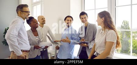 Gruppo di colleghi che chiacchierano e discutono sul lavoro durante una conversazione informale. Foto Stock