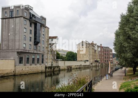 Vista sul fiume Avon mentre attraversa il sud del centro di Bath in un nuvoloso pomeriggio di settembre. I vecchi magazzini industriali lungo la w Foto Stock