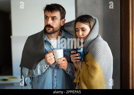 Congelamento di uomo e donna che soffrono di raffreddore o febbre influenzale o che hanno problemi con il riscaldamento centralizzato Foto Stock