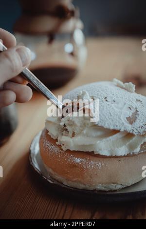 Persona che mangia tradizionale semla bun Foto Stock