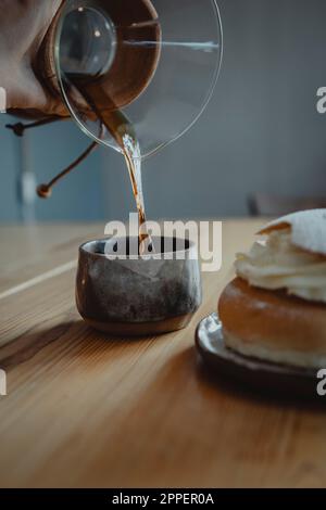 Tradizionale semla BUN su piatto e caffè versato Foto Stock