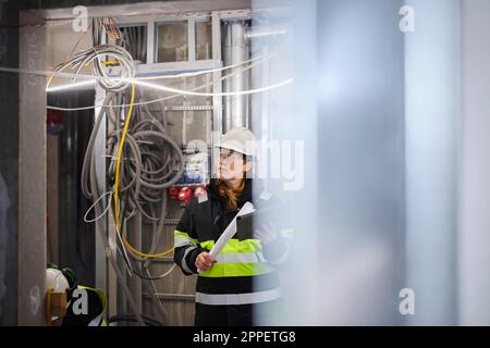 Ingegnere donna che utilizza un tablet digitale in cantiere Foto Stock