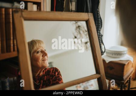 Senior donna cercando in specchio Foto Stock