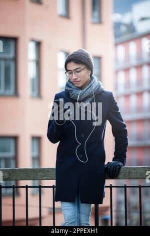 Bell'uomo con smartphone per strada Foto Stock
