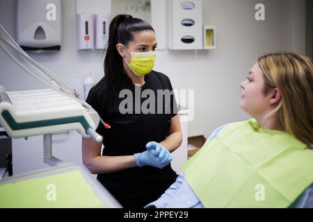 Dentista femminile con paziente in ufficio Foto Stock