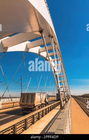 Autocarro con semirimorchio ribaltabile che attraversa il ponte, messa a fuoco selettiva Foto Stock