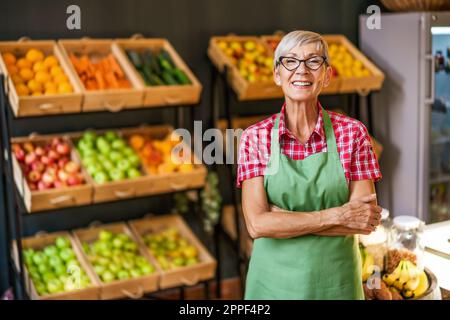 Donna matura lavora nel negozio di frutta e verdura. Ritratto del proprietario del supermercato di piccola impresa. Foto Stock