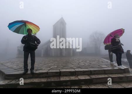 SA Pa, Vietnam - 28 FEBBRAIO 2012: I vietnamiti e i turisti visitano la chiesa nella nebbia mattutina. SA Pa. Foto Stock