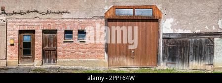 Facciata rurale vecchia con diverse porte e cancelli Foto Stock