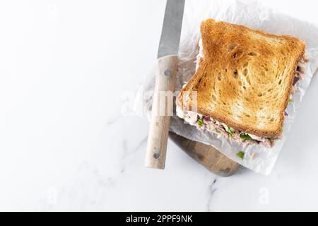 Panino di tonno con mayo e verdure su sfondo di marmo bianco Foto Stock