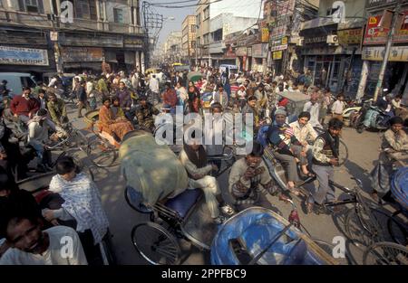 Traffico su una strada commerciale con un taxi risciò nella città vecchia di Delhi vecchia nella città di Delhi in India. India, Delhi, febbraio, 1998 Foto Stock