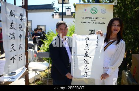 (230424) -- VALLETTA, 24 aprile 2023 (Xinhua) -- Charmaine St John, il sindaco di Santa Lucija (R) e Ji Nengwen, direttore cinese dell'Istituto Confucio dell'Università di Malta, presentano un'opera di calligrafia sull'amicizia Cina-Malta durante la 'Fiera di Primavera' di Santa Lucija, Malta, il 23 aprile 2023. La "Fiera di Primavera", caratterizzata da diverse attività culturali cinesi, si è tenuta la domenica presso il Giardino della Serenità, un tradizionale giardino cinese a Santa Lucija, Malta. La fiera, organizzata congiuntamente dal Centro Culturale Cinese di Malta e dal consiglio locale di Santa Lucija, è stata organizzata presso Foto Stock