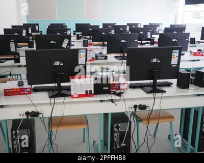 Sremska Mitrovica, Serbia, 15 maggio 2021 gruppo di computer ordinatamente collocato in un laboratorio informatico. Computer, monitor, cavi nella moderna classe della nuova scuola. Scrivanie scolastiche per alunni e studenti Foto Stock