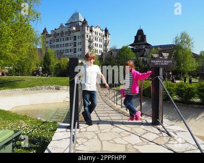 Stanisici, Bijelina, Bosnia ed Erzegovina aprile 25 2021 Un ragazzo di 8 anni e una ragazza di 7 anni, fratello e sorella, si trovano al ponte sospeso nel villaggio ethno. I bambini visitano i siti turistici Foto Stock