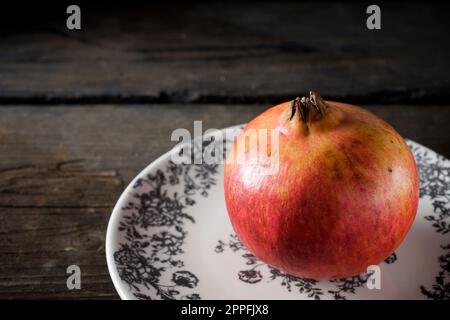 Melograno in ceramica decorata con motivi floreali Foto Stock