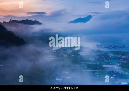 Misty alba sul Kintamani caldeira a Bali Indonesia Foto Stock