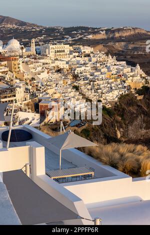 La città bianca di Fira con caldi raggi del tramonto sull'isola di Santorini Foto Stock