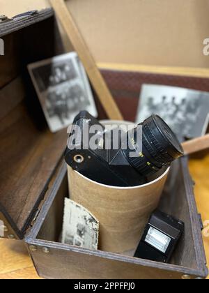 Una vecchia fotocamera reflex in un fotogramma e nel petto Foto Stock