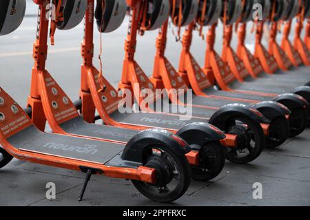 Fila di scooter elettrici condivisi o e-step con caschi in affitto sono in attesa di clienti in una strada a Melbourne, Victoria, Australia. E-mobil Foto Stock