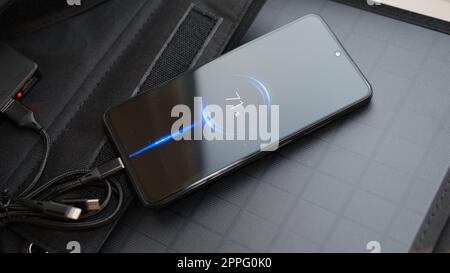 Collega le mani a uno smartphone portatile con pannello solare per la ricarica tramite cavo multiuso, power Bank, orologi, computer portatili. Energia pulita da utilizzare in campeggio o a casa SENZA elettricità. Foto Stock