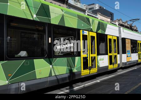 Tram di PTV trasporto pubblico Victoria visto obliquamente dal lato. Testo: Made in Melbourne - per Melbourne in tram Foto Stock