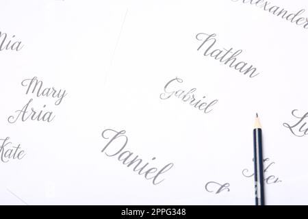 Matita ordinaria e diversi nomi dei bambini scritti su carta, primo piano Foto Stock