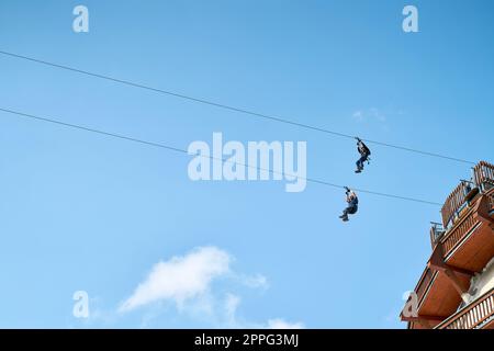 Due coraggiosi uomini avventurosi su una zipline a Magdeburg in Germania Foto Stock