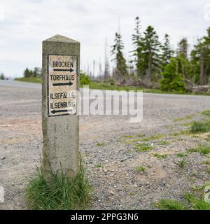 Cartello di pietra nel Parco Nazionale di Harz in Germania con indicazioni per Torfhaus, Ilsenburg, le cascate di Ilse e la cima di Brocken Foto Stock
