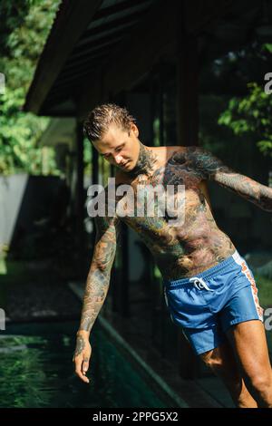 Giovane uomo bello con tatuaggi in stile giapponese. Foto Stock