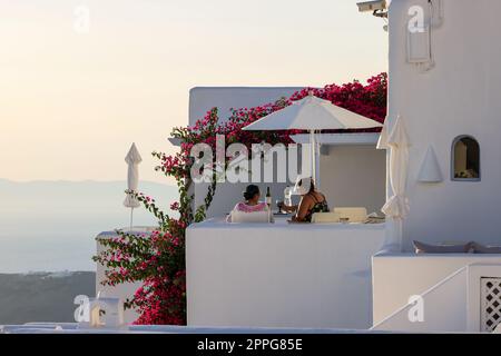 Bouganvillea rossa che si arrampica sulla parete della casa imbiancata a Imerovigli sull'isola di Santorini Foto Stock