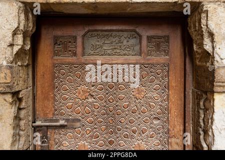 Antica porta in legno incisa della moschea storica di El Korafi, firmata dal creatore, il Cairo, Egitto Foto Stock