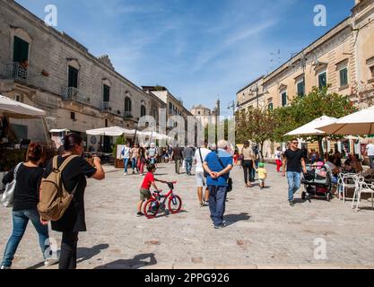 Il turista durante una passeggiata su strada acciottolata nei Sassi di Matera, quartiere storico della città di Matera. Foto Stock